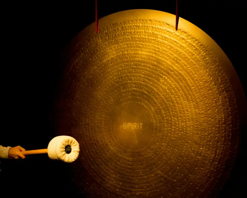 Azione di un battente su un grande gong, vibrazioni armoniche e benefiche