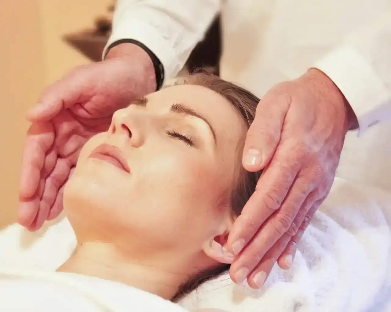 Mani ai lati di viso di donna che riceve un trattamento Reiki